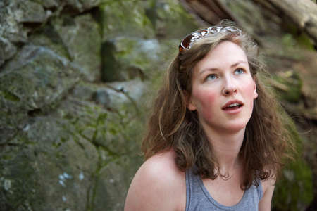 Young woman standing in front of rock wall