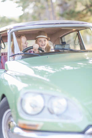 Two young girls in driving seat of carの写真素材