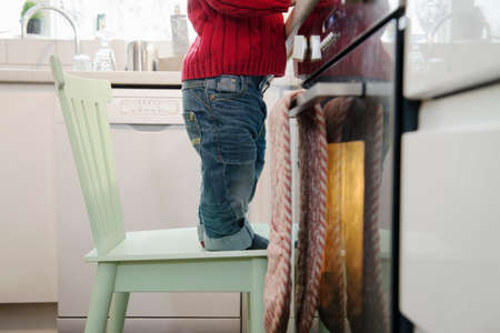Boy standing on chair in kitchen
