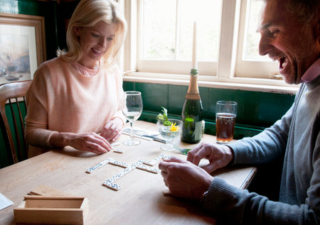 Couple drinking and playing dominoes in pubの写真素材