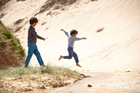 Two young boys playing on beachの写真素材