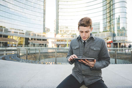 Portrait of young businessman commuter using digital tablet.