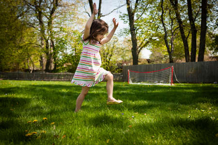 Young girl running in garden, low angle viewの写真素材