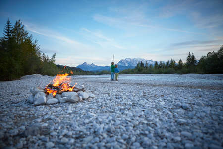Rear view of boys near campfire holding sticks, Wallgau, Bavaria, Germanyの写真素材