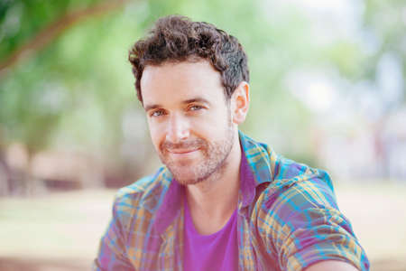 Portrait of mid adult man wearing checked shirt looking at camera smiling