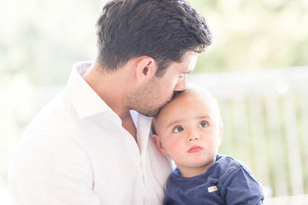 Father kissing young son on head