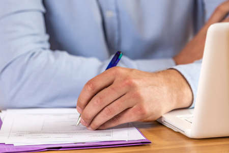 Hand of woman doing paperwork at deskの写真素材