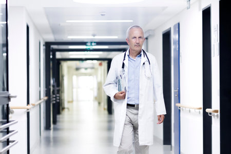 Male doctor walking along corridorの写真素材