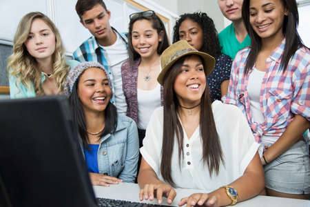 Group of teenagers working on computer in high school classの写真素材