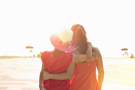 Rear view of mid adult woman and daughter on beach, Zhuhai, Guangdong, Chinaの写真素材