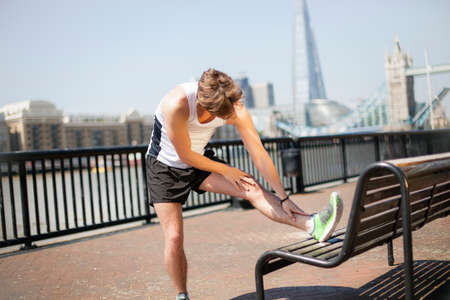 Runner stretching on riverfront, Wapping, Londonの写真素材
