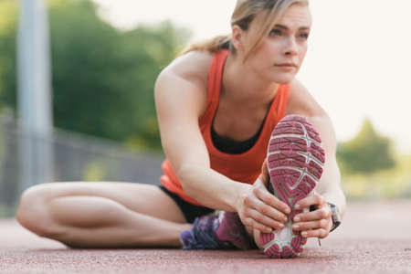 Young woman working out, stretching, outdoorsの写真素材
