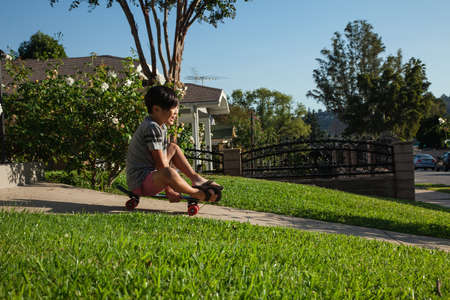 Boy skateboarding down gardenの写真素材
