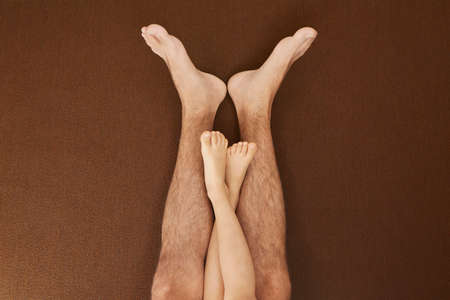 Child's legs on man's legs