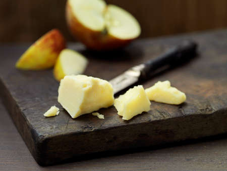 Mature cheddar cheese with apple slices on woodの写真素材