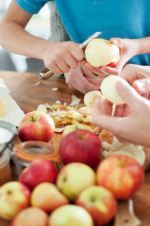 Cropped shot of father and sons hands peeling organic applesの写真素材