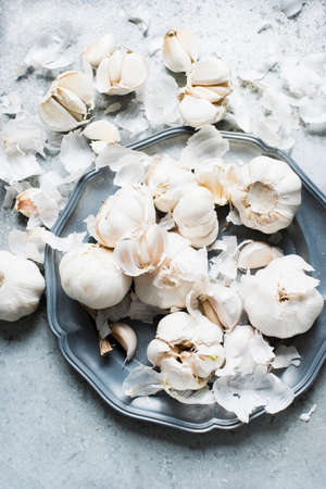 Overhead view of garlic bulbs and garlic cloves on serving dishの写真素材