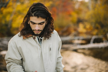 Young man, in rural environment, looking downの写真素材