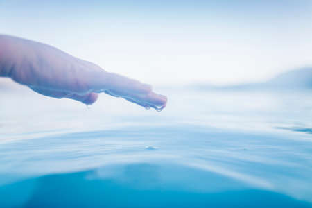 Hand above surface lagoon waterの写真素材