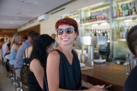 Happy mature woman looking over her shoulder from barの写真素材