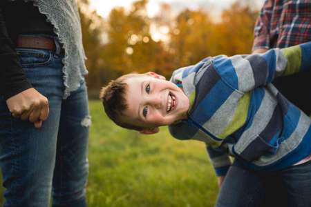 Boy with parents bending forwards looking at camera smilingの写真素材