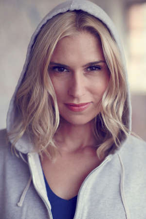 Portrait of blond mid adult woman wearing hooded top in warehouse