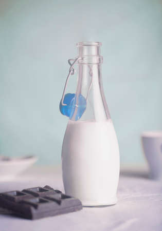 Opened bottle of milk, chocolate barの写真素材