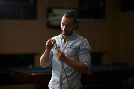 Man chalk rubbing pool cueの写真素材