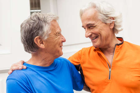 Two happy senior male runners at front doorの写真素材