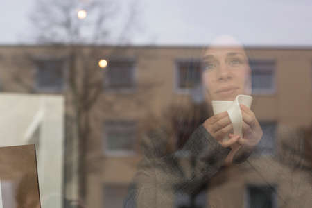Young woman gazing through cafe window