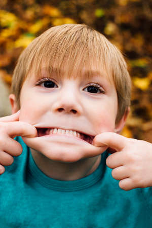 Portrait of young boy pulling face, close-upの写真素材