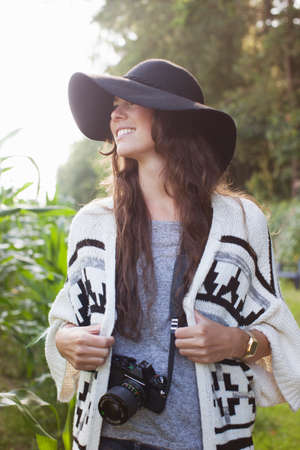 Young female photographer strolling in field