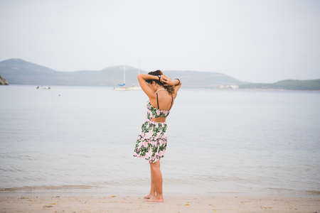 Woman standing at water's edge, Alghero, Sassari, Sardinia, Italy