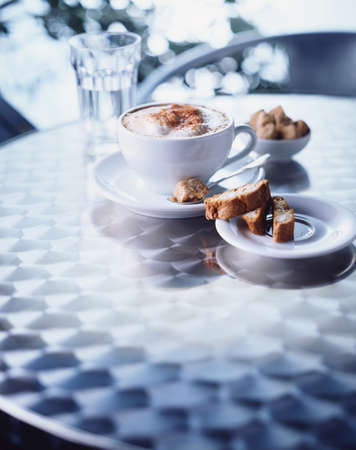 Cup of cappuccino, biscotti on tableの写真素材