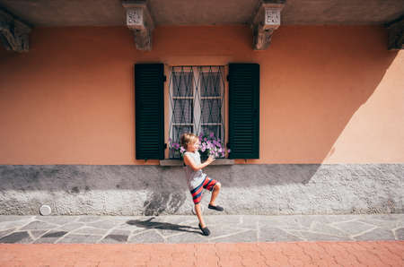 Boy running past window with shutters, Schruns, Vorarlberg, Austria
