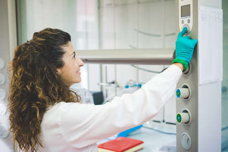 Female scientist switching on chemical hoodの写真素材