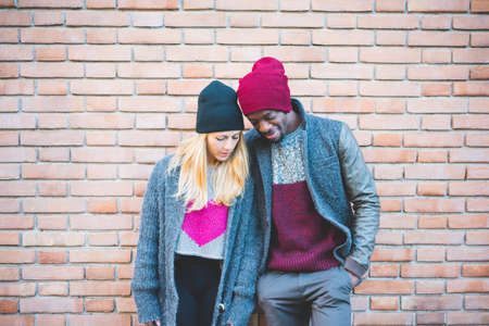 Couple enjoying quiet moment against brick wallの写真素材