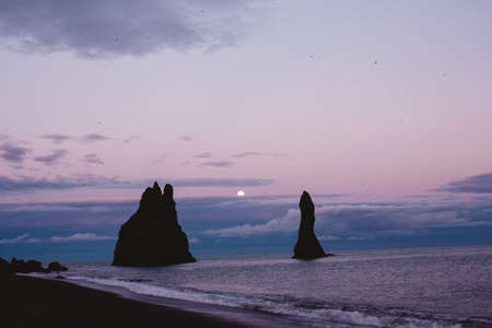 Silhouette of rock formations on coastline at sunset, Vik, Icelandの写真素材