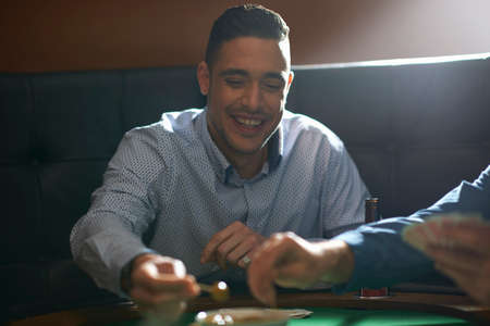 Man gambling key playing card game at pub card tableの写真素材