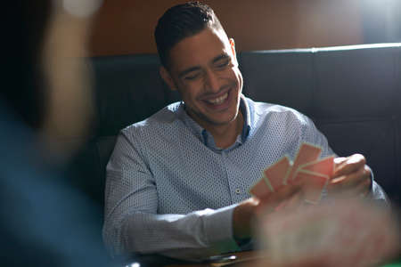 Over shoulder view of men playing cards in traditional UK pubの写真素材