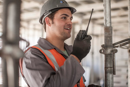 Builder using walkie talkie on construction site