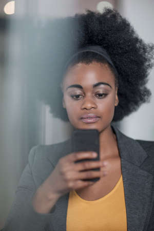 Young businesswomen reading smartphone text at officeの写真素材
