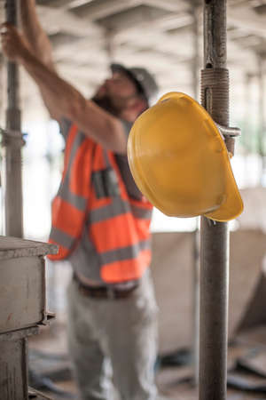 Male builder working on scaffolding on construction siteの写真素材