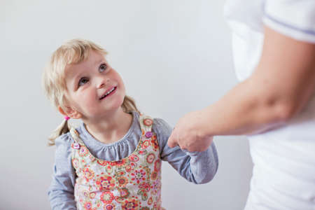 Girl holding nurses hand looking up smilingの写真素材