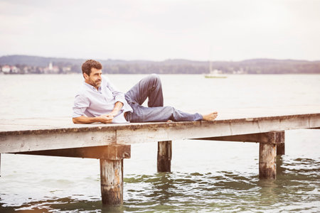 Mature man relaxing on pierの写真素材