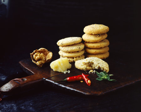 Stacks of homemade walnut chilli cheese oatcakes on vintage wooden trayの写真素材