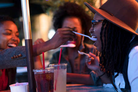 Group of female friends, having drinks at cafe, outdoorsの写真素材