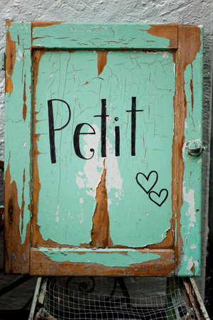 Rustic green vintage door with 'petit' signの写真素材