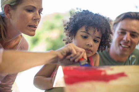 Family doing crafts together, painting woodの写真素材