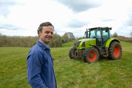 Portrait of farmer in field in front of tractorの写真素材